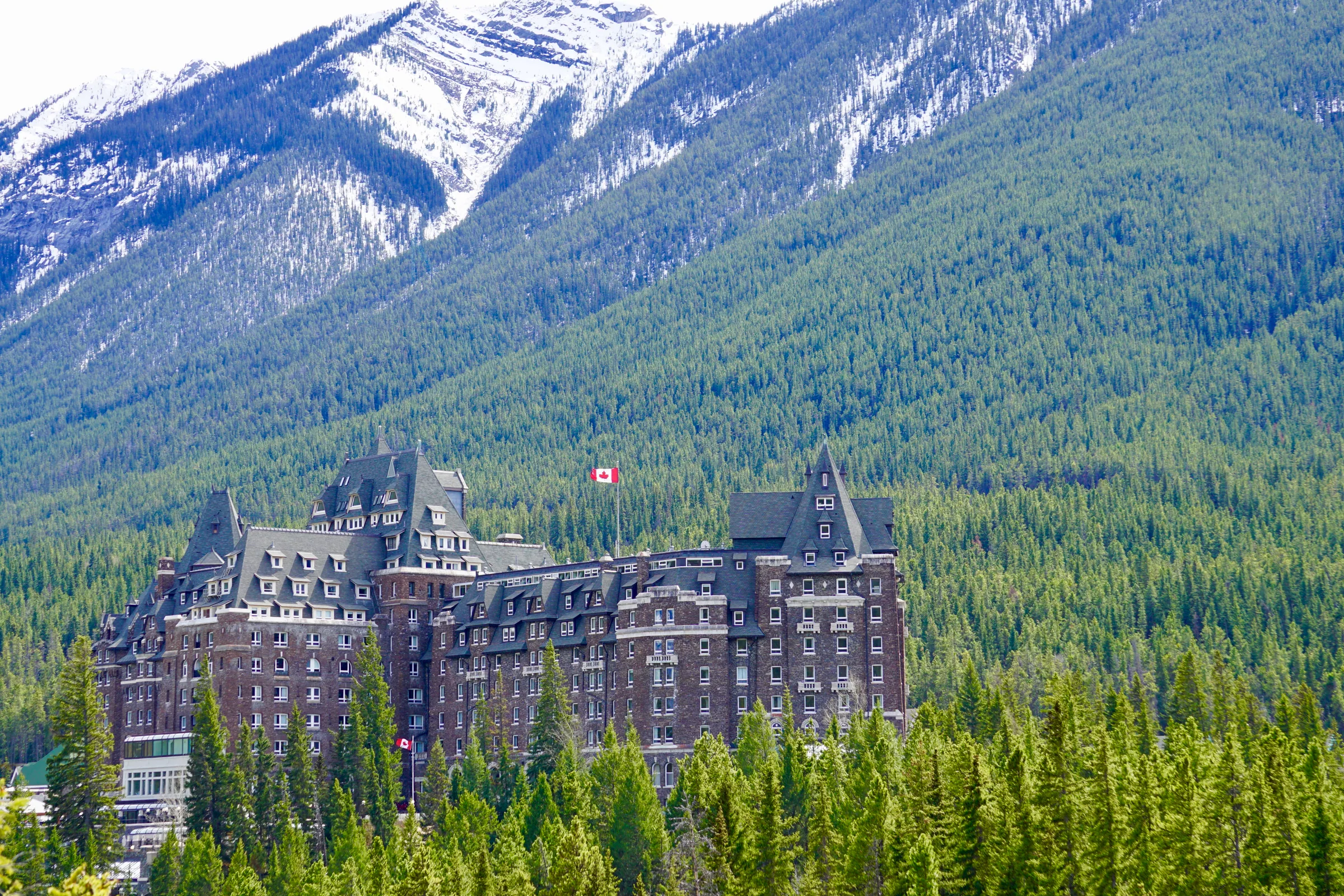 The Banff Springs Hotel below forested mountain slopes.