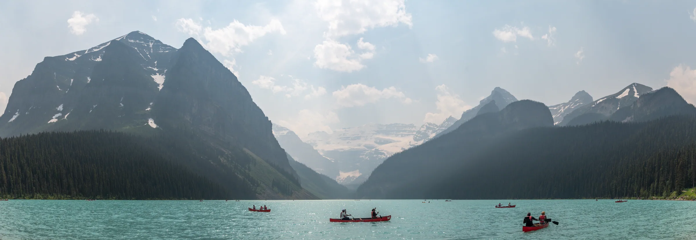 Lake Louise and its mountain backdrop partially obscured by wildfire smoke.