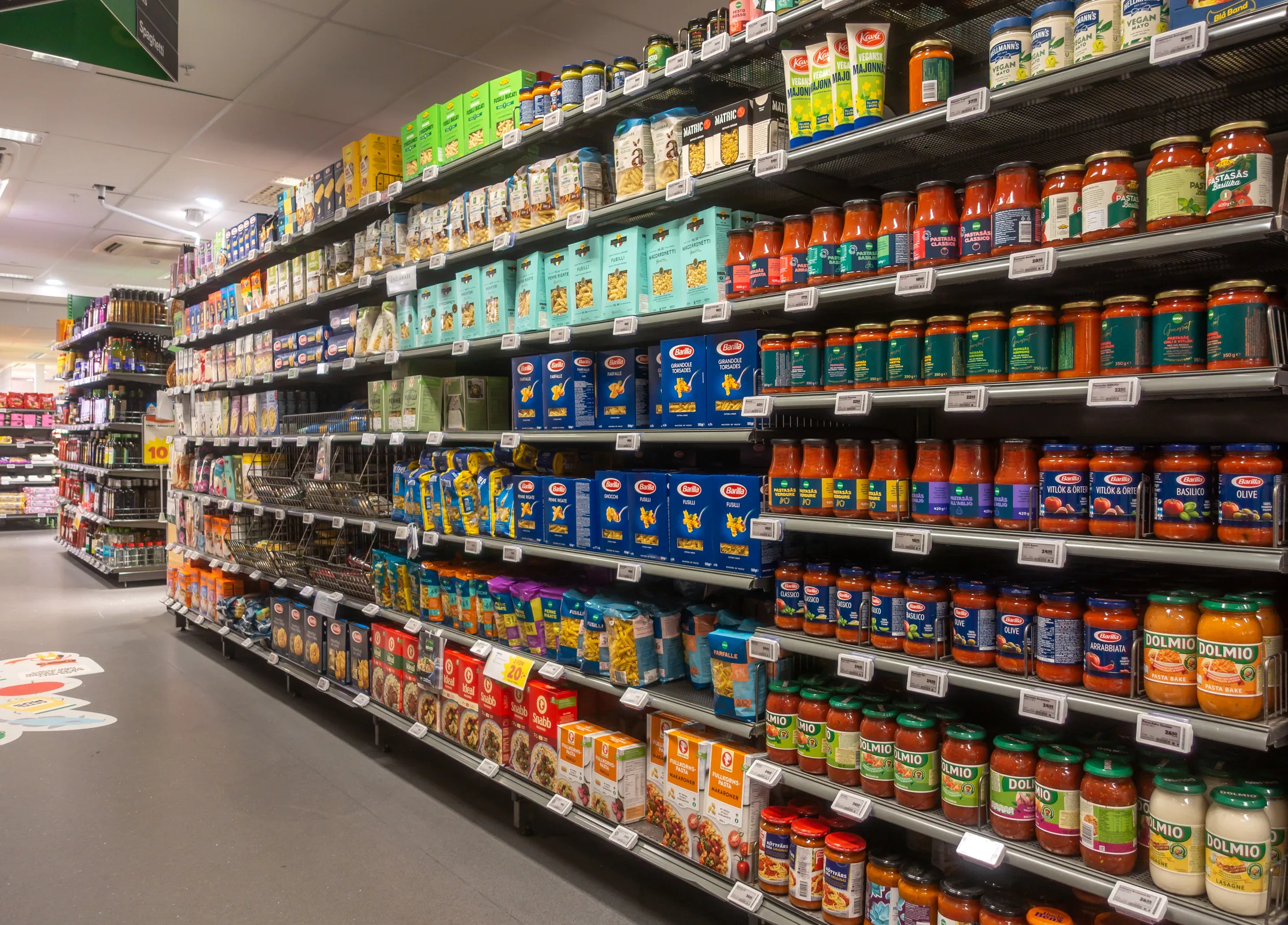 A well-stocked supermarket aisle with packaged food and pantry staples.