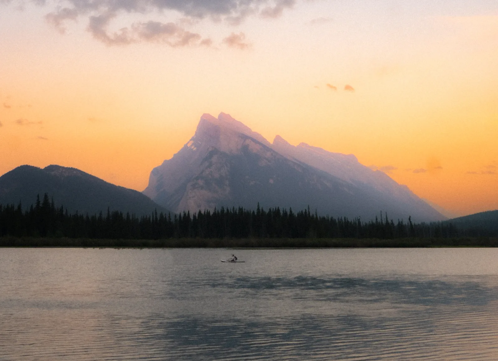 Mount Rundle glowing orange above Vermilion Lakes at dusk.